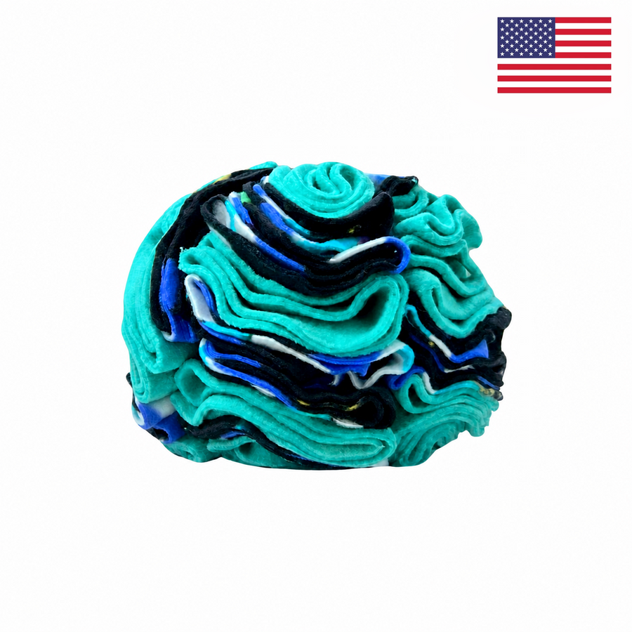 A small, abstract teal and blue object resembling a brain sits on a white background. A small American flag appears in the top right corner, hinting that this could be the PierrePark Snuffle Ball for Dogs - Turquoise Fireflies, an interactive puzzle toy made in the USA.